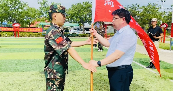 2、压球(中国)人力资源总监张浩敏向新员工交授营旗.PNG